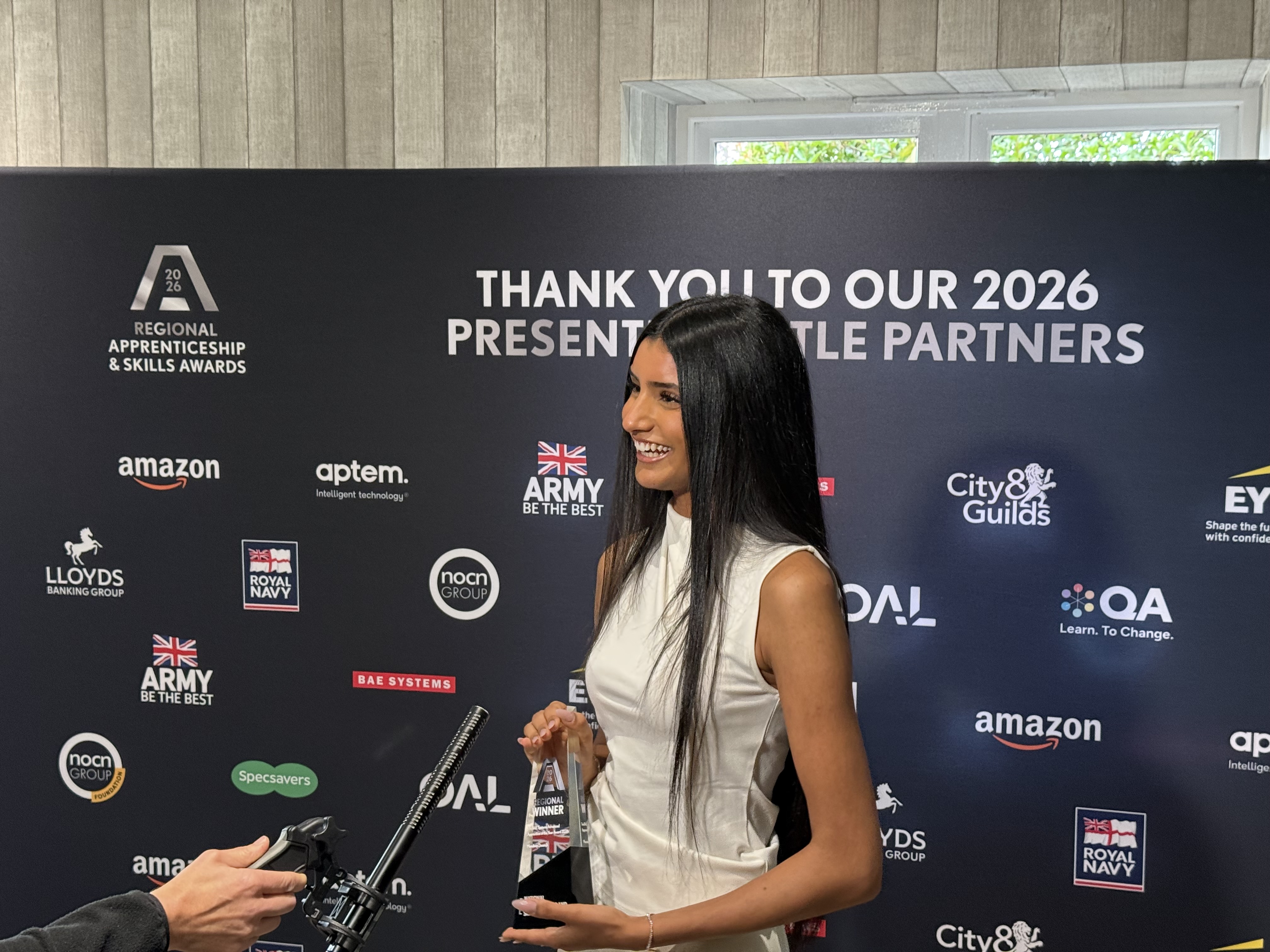 Mandeep Dosanjh being interviewed while holding her West Midlands apprenticeship award